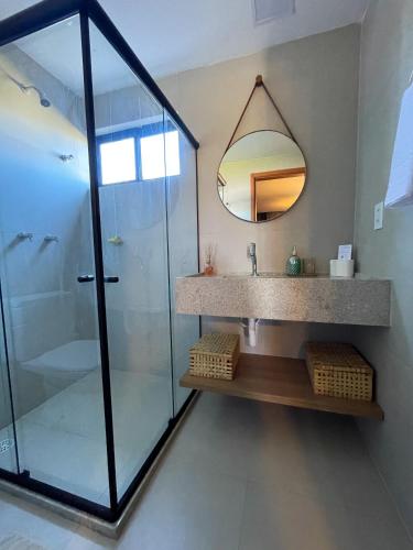 a bathroom with a shower and a sink and a mirror at Mani Milagres Studio - Gamboa Patacho in Pôrto de Pedras