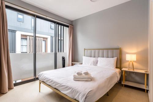 a bedroom with a bed and a large window at Westend 3 bedroom Split level Townhouse Next to River in Brisbane