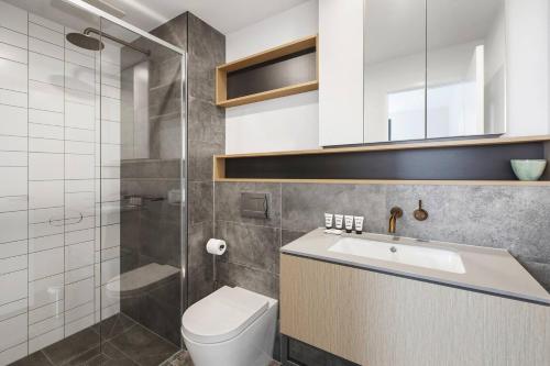 een badkamer met een toilet, een wastafel en een douche bij Smith Street Crossing - Central City-view Serenity in Melbourne