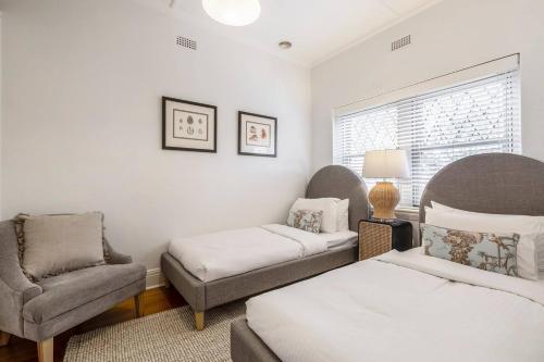 a bedroom with a bed and a couch and a chair at Tranquil Inner-east Haven Moments from High Street in Melbourne