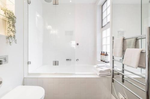 a white bathroom with a shower and a toilet at Tranquil Inner-east Haven Moments from High Street in Melbourne