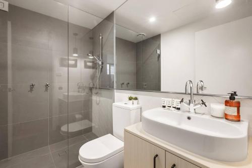 a bathroom with a sink and a toilet and a shower at Modern and Cosy Parkland Retreat near Yarra River in Melbourne
