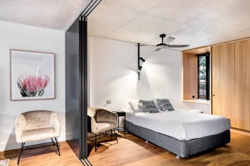 1 dormitorio con 1 cama, mesa y sillas en A Designer's Dream in the Heart of Trendy Fitzroy, en Melbourne