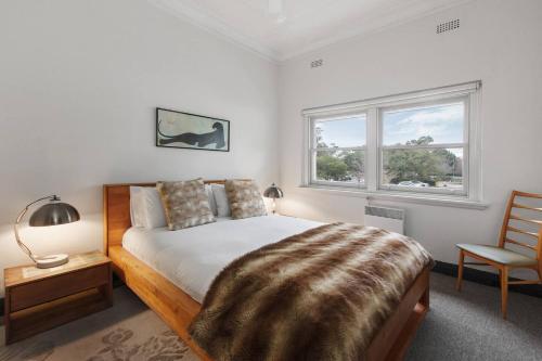 - une chambre avec un lit, une chaise et une fenêtre dans l'établissement Parkside Hideaway - Beautiful Art Deco near Zoo, à Melbourne