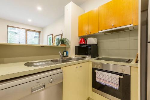 a kitchen with a sink and a microwave at Experience the St Kilda Vibe from a Cosy Retreat in Melbourne