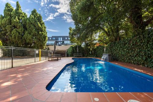 a swimming pool in a yard with a fence at Experience the St Kilda Vibe from a Cosy Retreat in Melbourne
