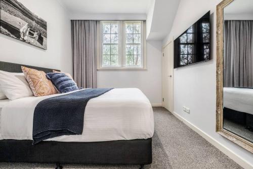 a bedroom with a large bed and a mirror at Inner City Living in a Modern Slice of History in Melbourne