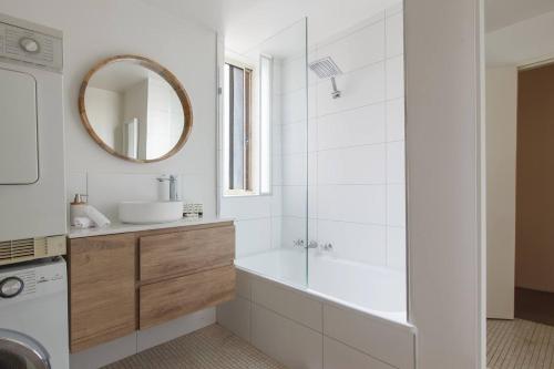 a bathroom with a tub and a sink and a mirror at Spacious Suburban Comfort Perfect for Families in Melbourne