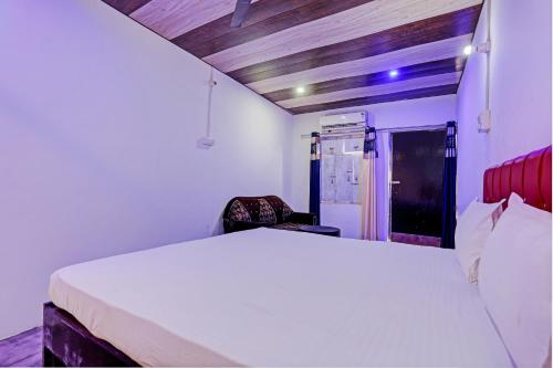 een slaapkamer met een wit bed in een kamer bij Super OYO Unnati Farm And Resort in Nūrpur