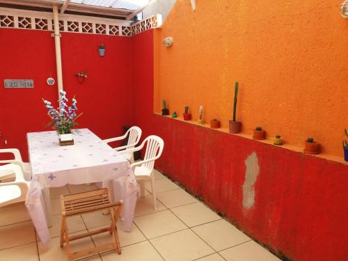 a table and chairs in a room with a red wall at Sol e Mar 850mts do mar Ingleses Satinho in Florianópolis