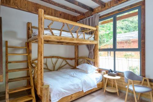 Zhumaxi Leisure Lodge في تشانغجياجيه: غرفة نوم مع سرير بطابقين وسلم