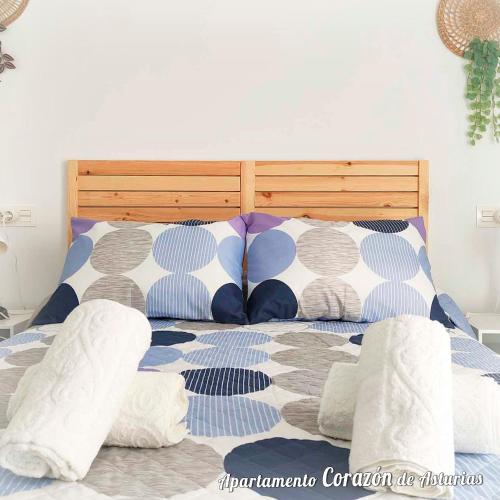 Una cama con almohadas azules y blancas. en CORAZÓN DE ASTURIAS, en Piedras Blancas