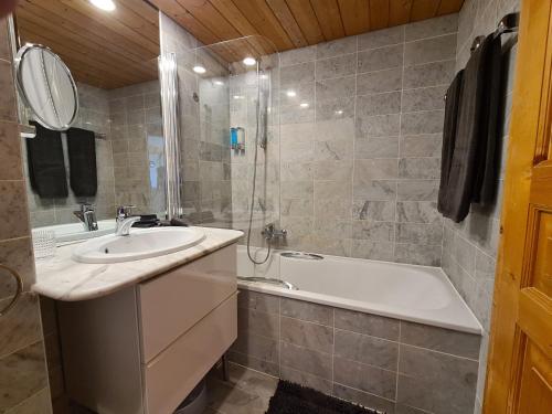 y baño con lavabo y bañera. en Appartement Bristol Villars-sur-Ollon en Villars-sur-Ollon