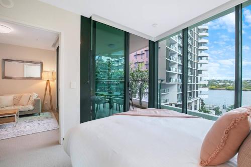 a bedroom with a bed and a large window at 'Riverfront Flow' Poolside and Portside in Hamilton in Brisbane