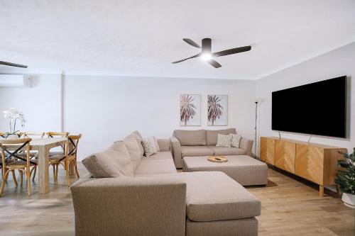 a living room with a couch and a flat screen tv at Toowong Village Tranquility - A Slice of Brisbane in Brisbane