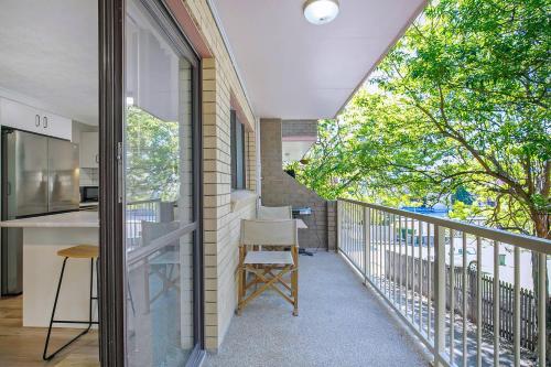 a balcony of a house with a table and a chair at Toowong Village Tranquility - A Slice of Brisbane in Brisbane