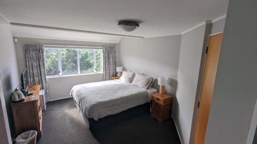 a small bedroom with a bed and a window at Harbour Lodge Wellington in Wellington