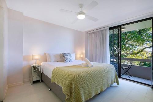 a bedroom with a bed and a large window at 'Riverside Terrace' Inner-city Retro-chic with Pool in Brisbane