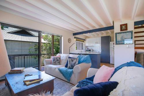 a living room with a couch and a table at Tropical Dreaming in the Heart of Indooroopilly in Brisbane