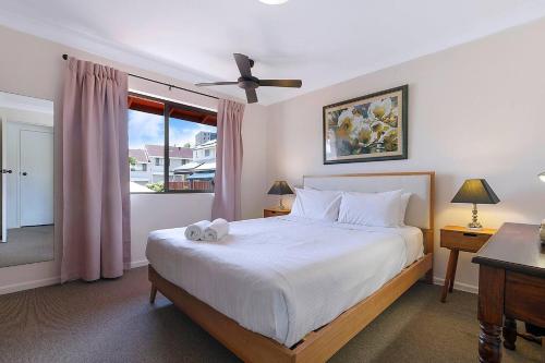 a bedroom with a large bed and a window at Tropical Dreaming in the Heart of Indooroopilly in Brisbane