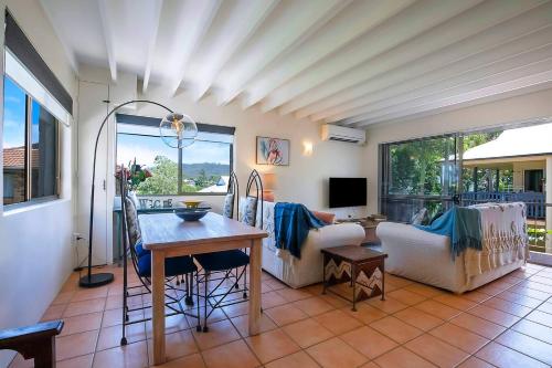 a living room with a table and a couch at Tropical Dreaming in the Heart of Indooroopilly in Brisbane