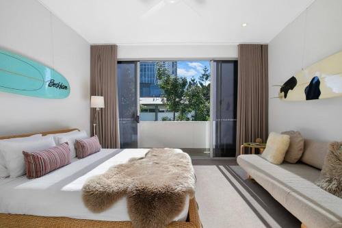 a bedroom with a large white bed and a couch at The Sun Catcher - A Trendy South Brisbane Terrace in Brisbane