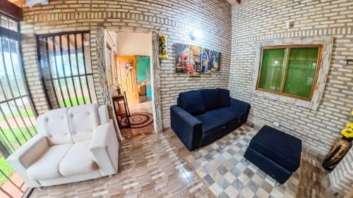 a living room with two chairs and a blue couch at La Casita de Aregua in Itauguá