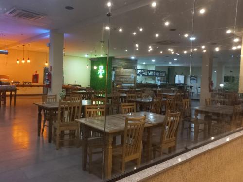 a restaurant with wooden tables and chairs in a room at Aldeia das Aguas Village in Barra do Piraí