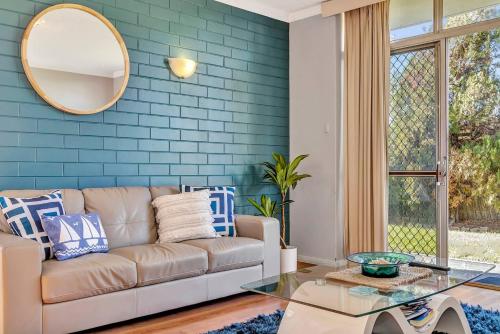 a living room with a couch and a mirror at Captain's Rest - Seaside Lifestyle on West Beach in Adelaide