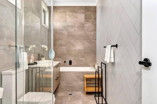 Un baño con ducha, bañera y lavabo. en 'Brightly Brompton' A Family Delight by the Park, en Adelaida