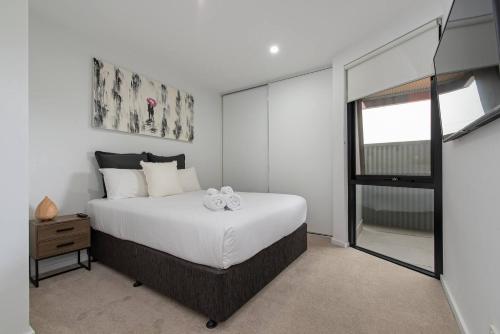 a bedroom with a large white bed and a window at Perfect Prospect Among City's Dining Hotspots in Adelaide