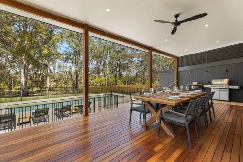 a large deck with a table and chairs on it at Thalassa Huskisson by Experience Jervis Bay in Huskisson