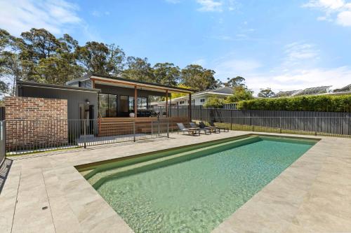 a swimming pool in the backyard of a house at Thalassa Huskisson by Experience Jervis Bay in Huskisson