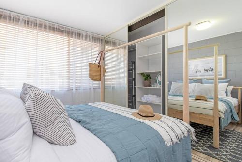 a bedroom with a canopy bed with a hat on it at Scandi Beach Breeze Minutes from Glenelg Beach in Glenelg