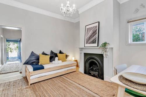 ein Wohnzimmer mit Couch und Kamin in der Unterkunft The Lemon Tree - Charming Cottage in North Adelaide in Adelaide