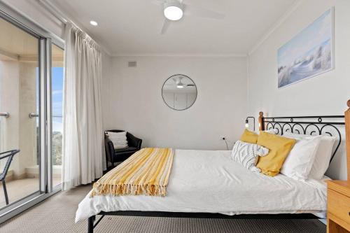 um quarto com uma cama grande e almofadas amarelas em Beachside Beauty - Iconic Beachfront Panorama em Semaphore