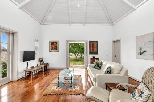 ein Wohnzimmer mit Couch und Fernseher in der Unterkunft Time and Tide Hideaway - A Spacious Beachside Escape in Adelaide