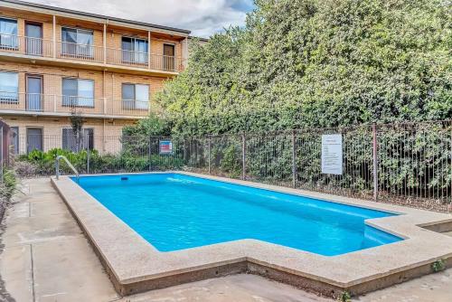 a swimming pool in front of a building at Coastal Comfort with a Pool opposite Henley Beach in Adelaide