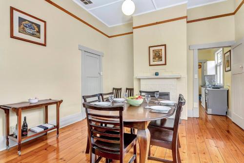 a kitchen and dining room with a table and chairs at 'The Nook' Peaceful Toorak Gardens Retro Cottage in Adelaide