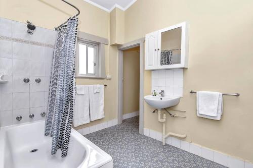 ein Badezimmer mit Badewanne und Waschbecken in der Unterkunft 'The Nook' Peaceful Toorak Gardens Retro Cottage in Adelaide
