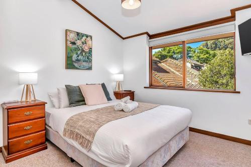 Norwood的住宿－'The Redstone' Experience Adelaide's Inner-east，一间卧室设有一张大床和一个窗户。
