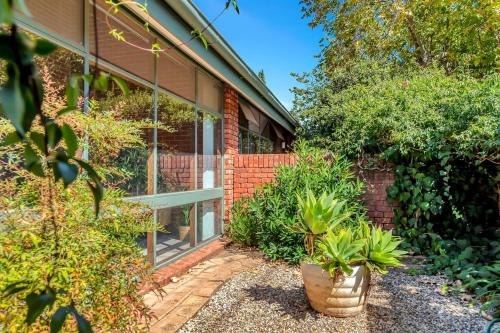 a brick house with plants in front of it at 'The Redstone' Experience Adelaide's Inner-east in Adelaide
