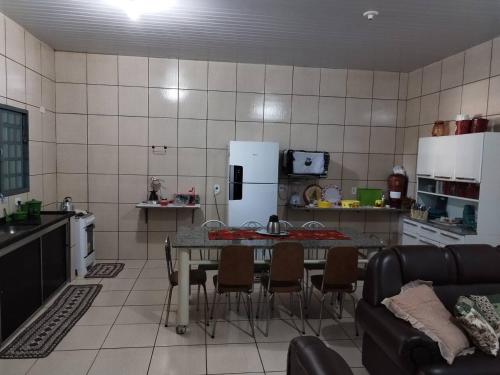 a kitchen with a table and chairs and a refrigerator at Rancho Imperador in Pôrto Primavera