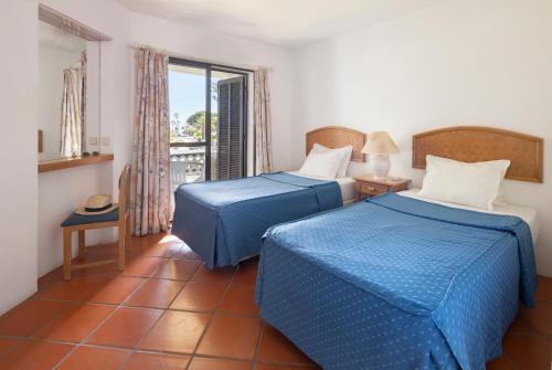 a hotel room with two beds and a window at Balaia Golf Village in Albufeira