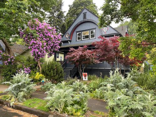 a house with a garden of flowers in front of it at Cozy PDX Hideout, Ideal Location in Portland