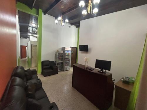 ein Wohnzimmer mit einem Sofa und einem TV in der Unterkunft SEVEN DAYS HOTEL B&B in San Pedro Sula