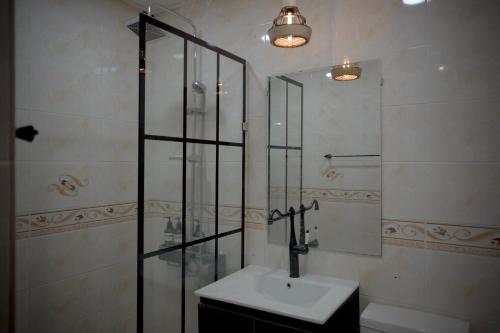 a bathroom with a sink and a glass shower at Greenside Pension in Seogwipo