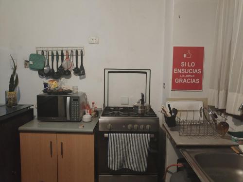 a kitchen with a black stove and a microwave at CASA HOSTEL 129-A in Cajamarca