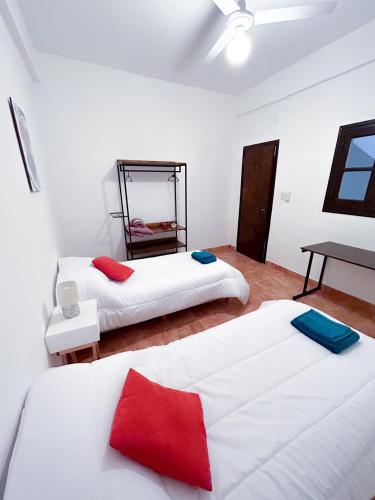 um quarto com duas camas em vermelho e branco em La Casita Amarilla en Salta em Salta
