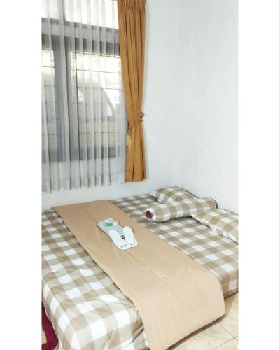 two beds sitting next to each other in a room at Berkah Huni , CIATER in Sarireja